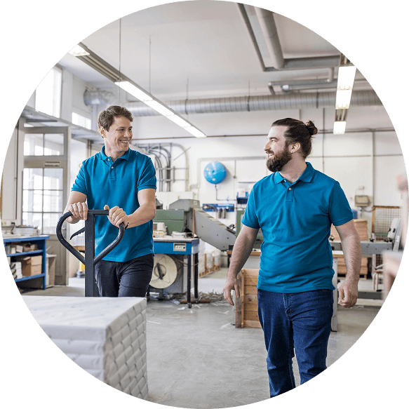 Two men smiling in a warehouse setting
